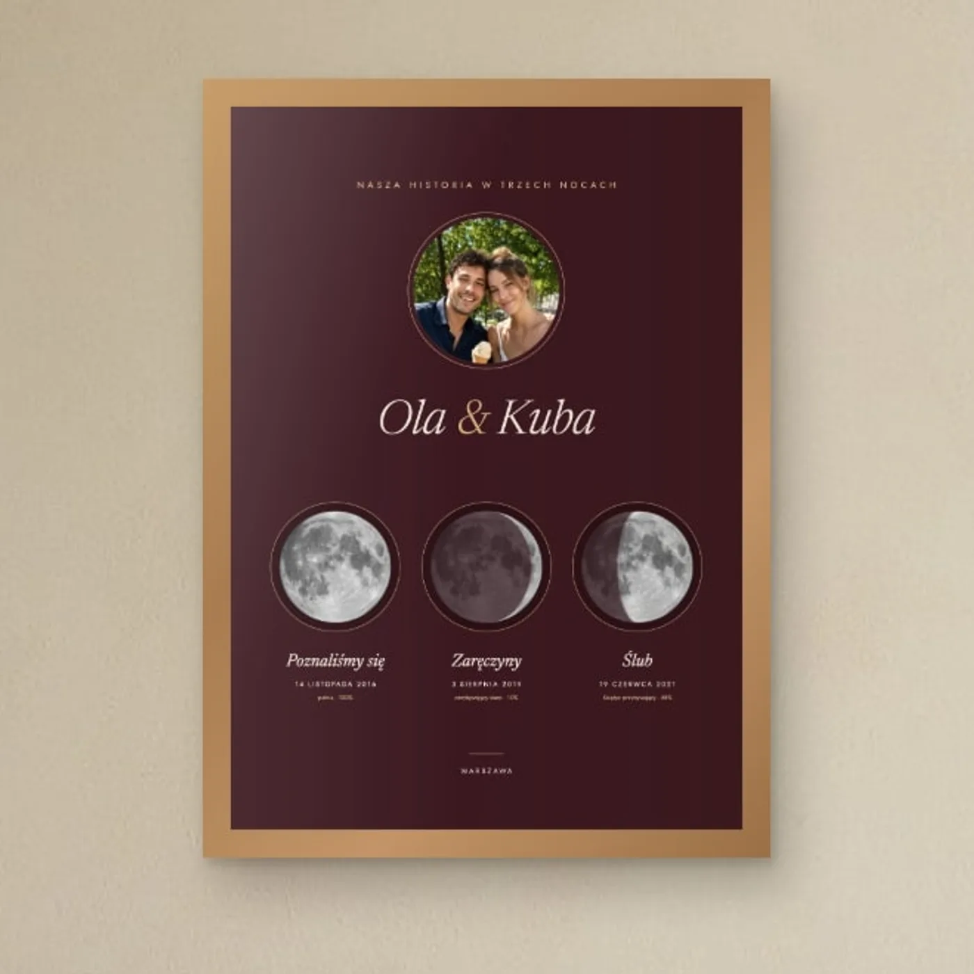 Bordowy plakat z trzema Księżycami w różnych fazach – poznanie, zaręczyny, ślub – i zdjęciem pary, w drewnianej ramie w sypialni
